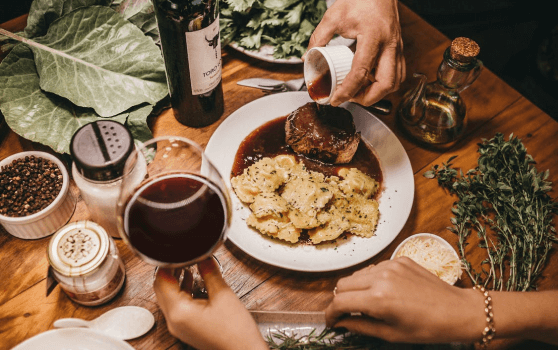 Bild von oben auf einen Tisch mit Essen und Wein.