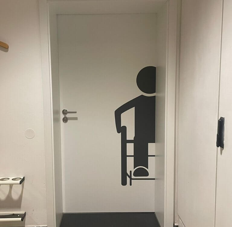 Weiße Tür mit einem Rollstuhl-Icon.