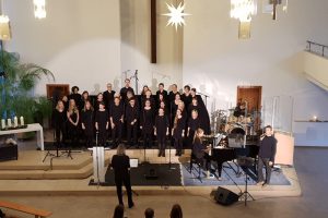 Singende Gruppe von schwarz gekleideten Menschen.