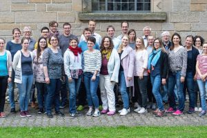 Frontales Gruppenbild von in etwa 25 Personen.